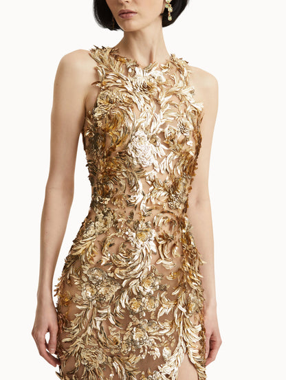 Zoomed in image of model wearing sleeveless gold-embroidered gown with feathers unfurling across a tulle base.