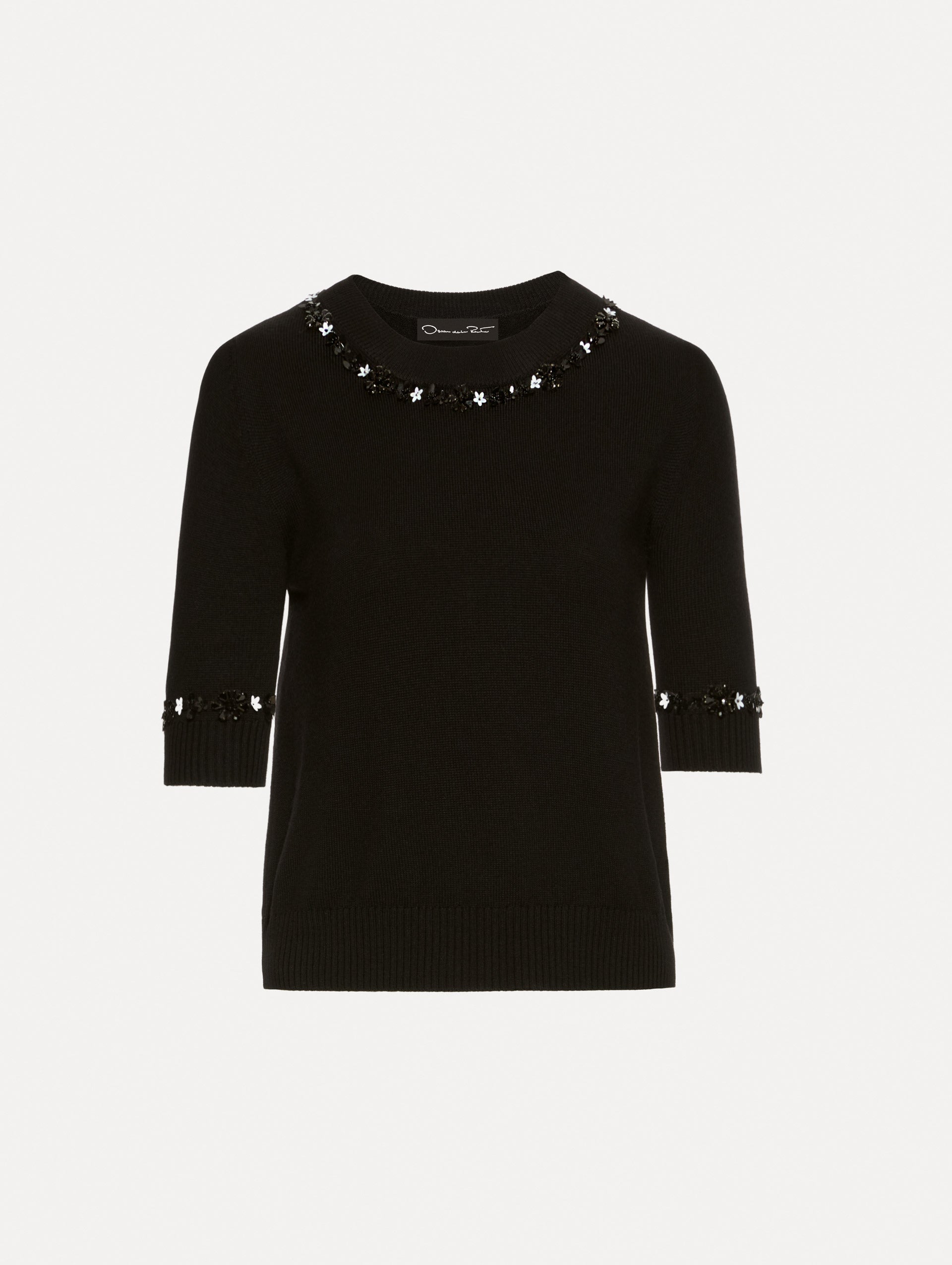Short sleeve black pullover with a crew neckline and intricate sequin embroidery of ivory and noir florets which trace the trim