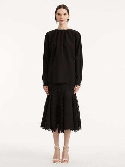 full body front view of model wearing black long sleeve top.