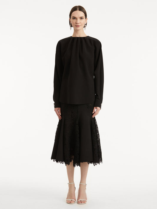 full body front view of model wearing black long sleeve top.