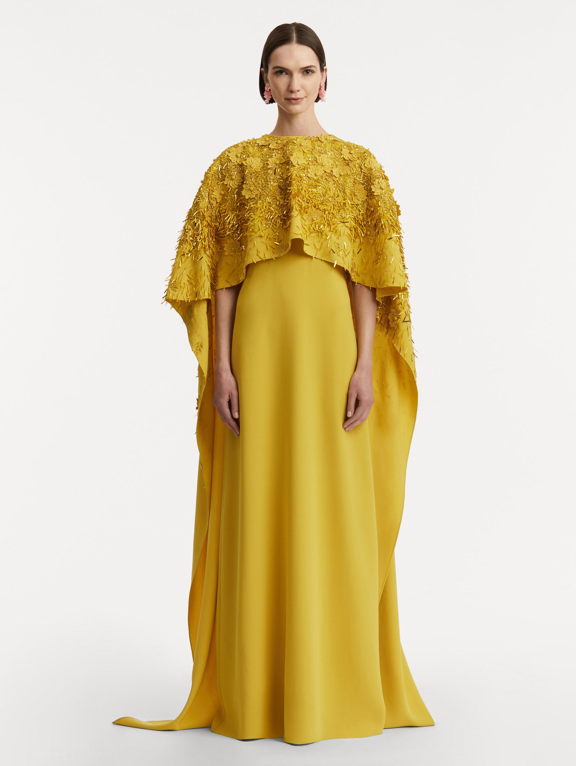 Full body front view of model wearing a yellow caftan with gold sequin and peony embroidery.