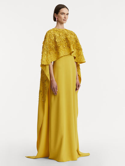 Full body side view of model wearing a yellow caftan with gold sequin and peony embroidery.