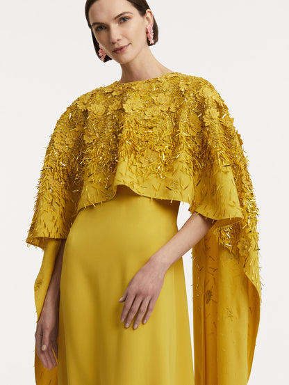 Zoomed in photo of model wearing a yellow caftan with gold sequin and peony embroidery.
