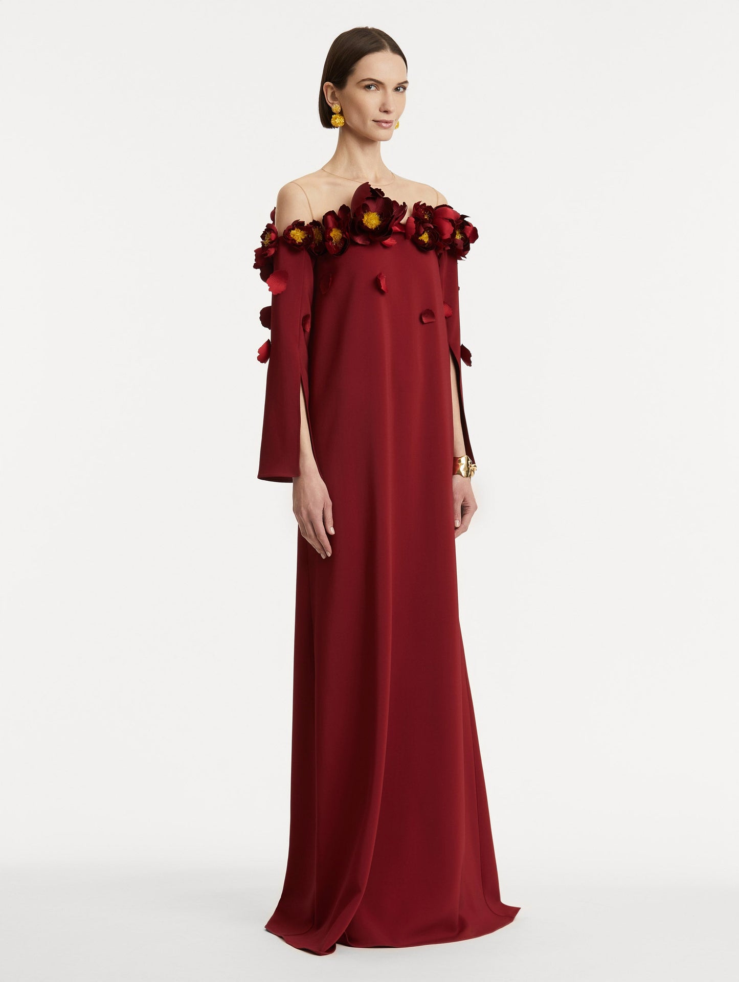 Full body side view of model wearing red split sleeve caftan with peony appliqués.