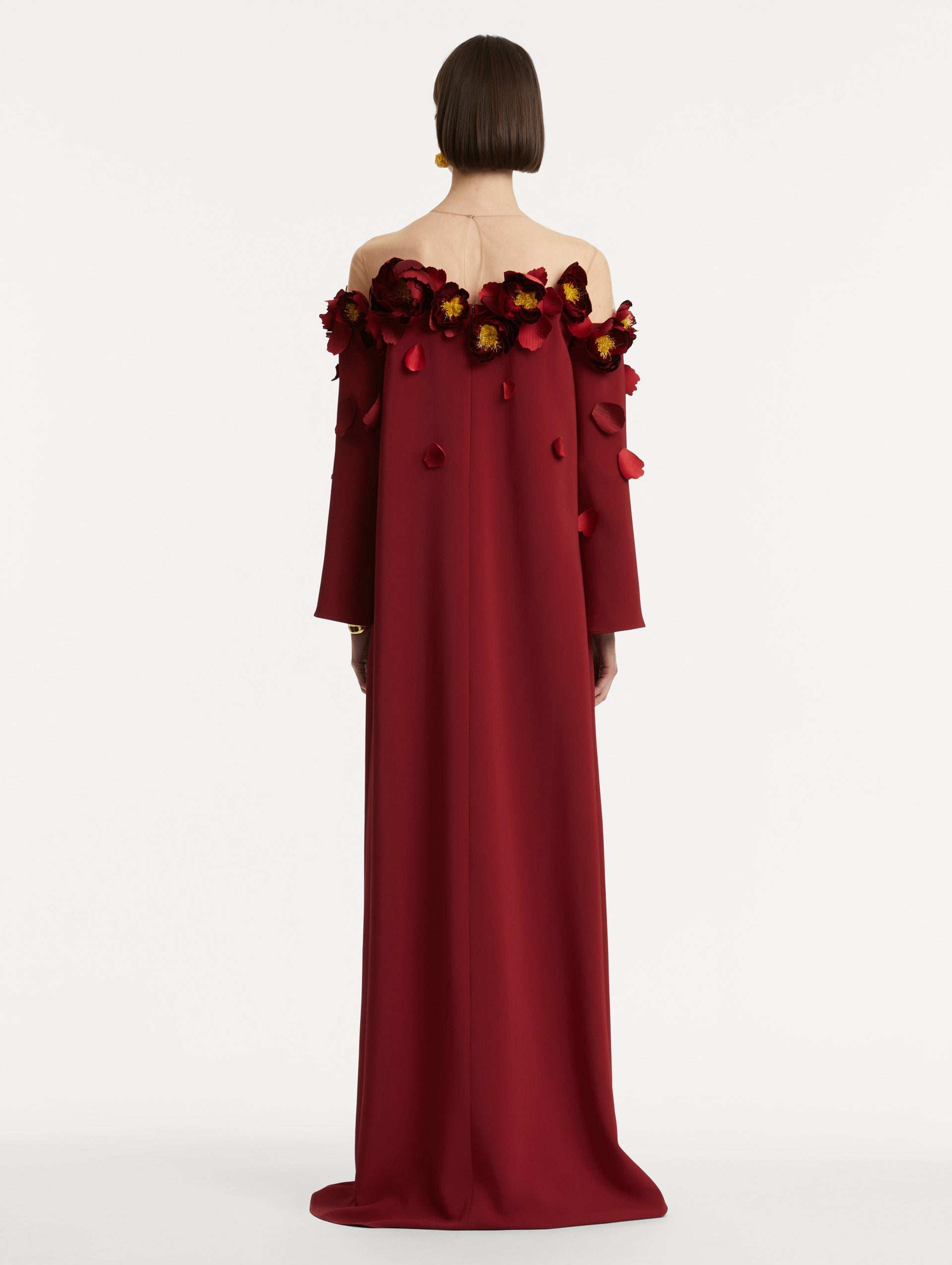 Full body back view of model wearing red split sleeve caftan with peony appliqués.