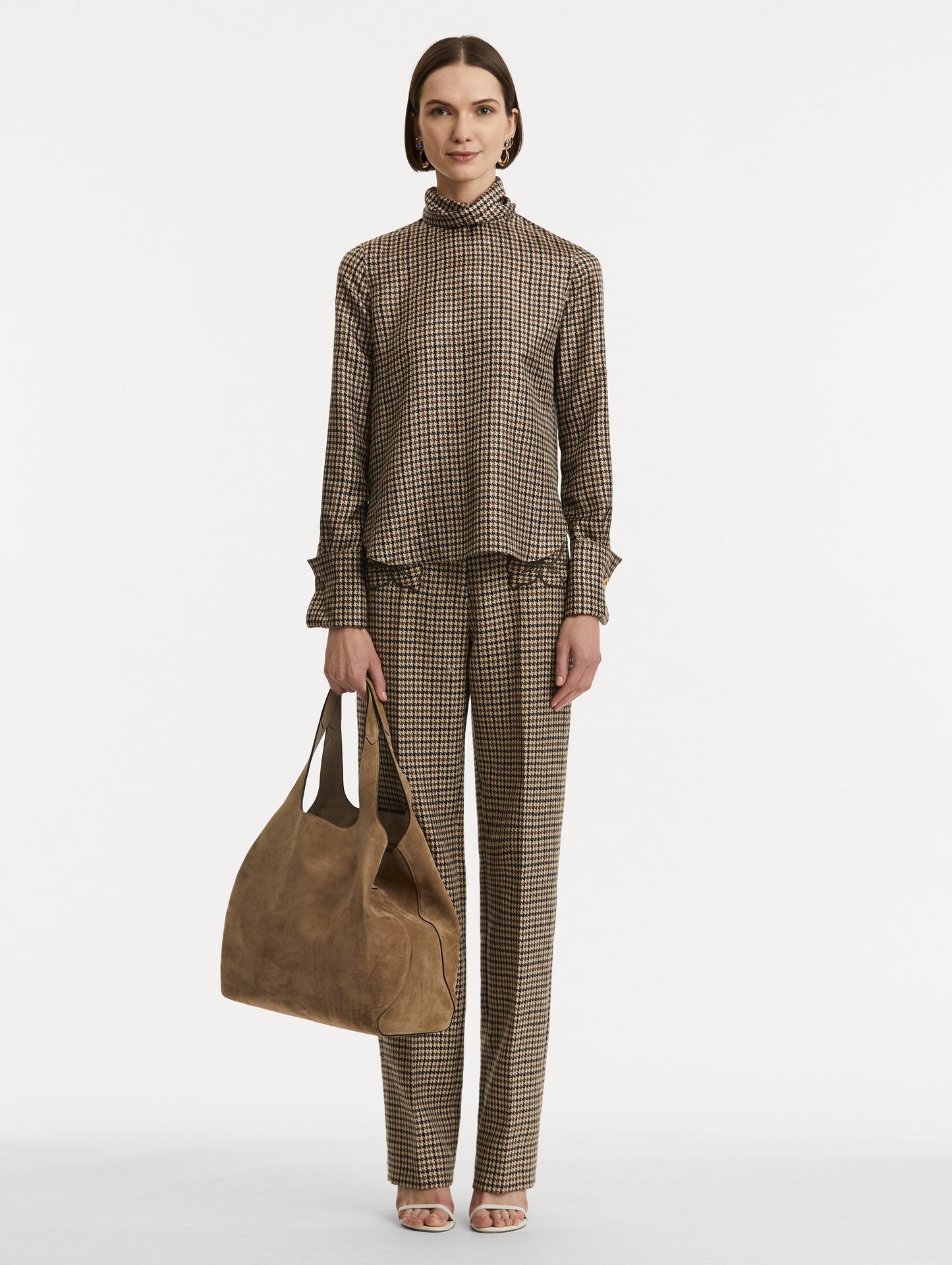 Full body image of model holding The Topaz in a taupe side view.