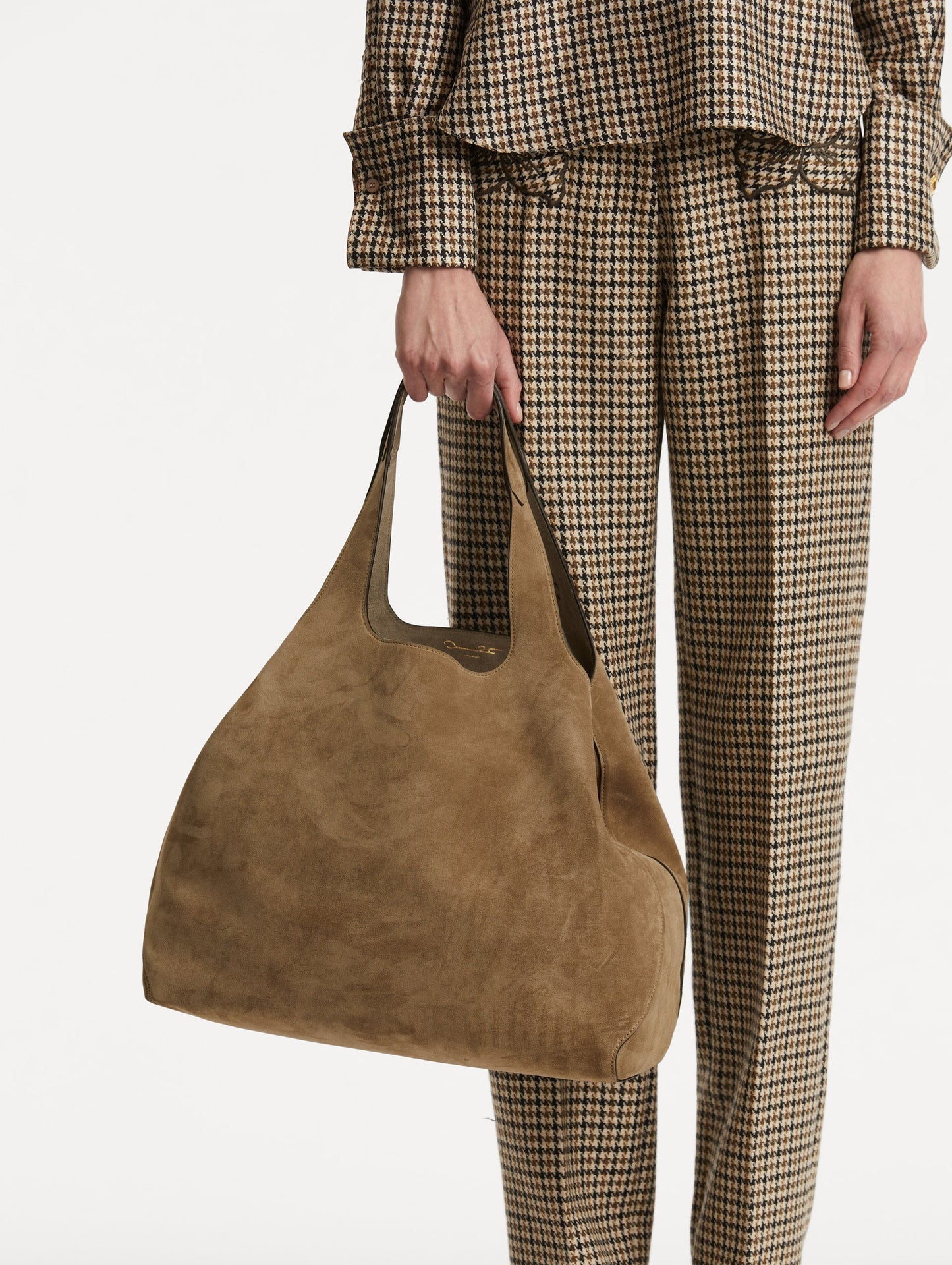 Photo of model holding The Topaz in a suede taupe front view.