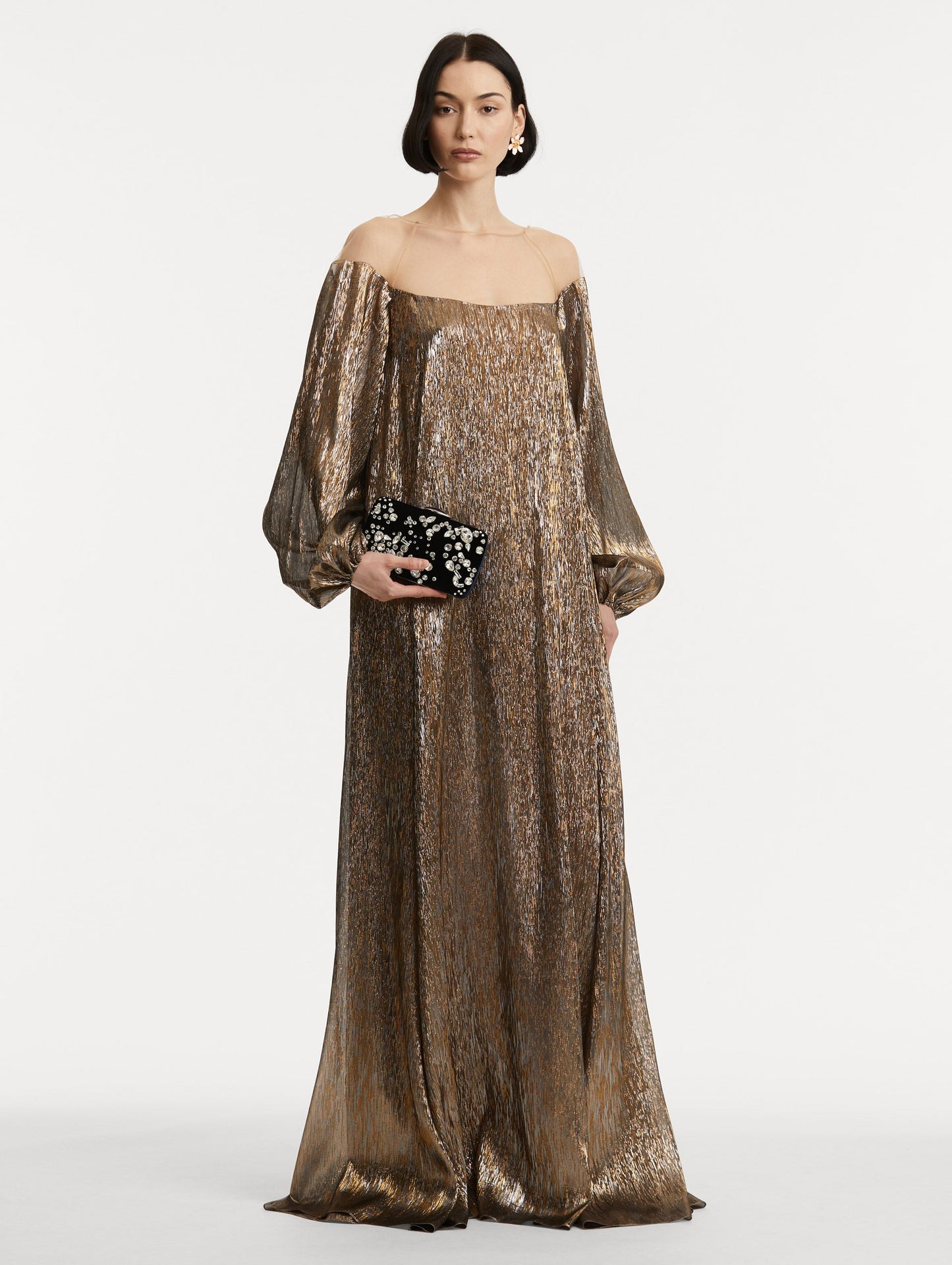 Full body image of model holding clutch with multi-dimensional crystal embroidery and faceted stones scattered across canvas.