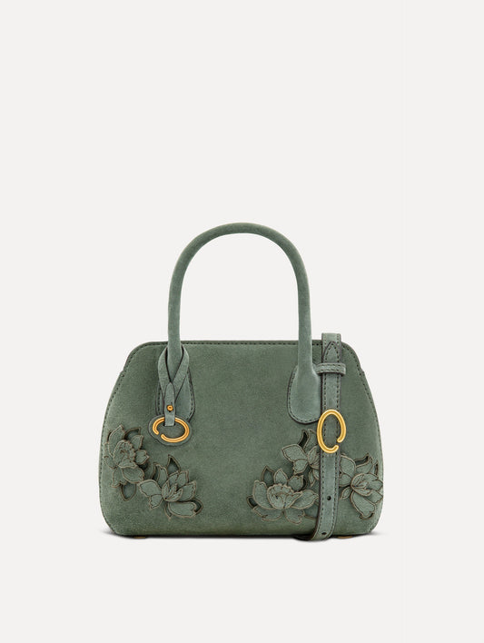 The Mini Ivy With Laser Cut Flowers in sage has a compartment with top handles and a removeable shoulder strap with various Oscar 'O' emblems on the hangtag and magnetic closure.