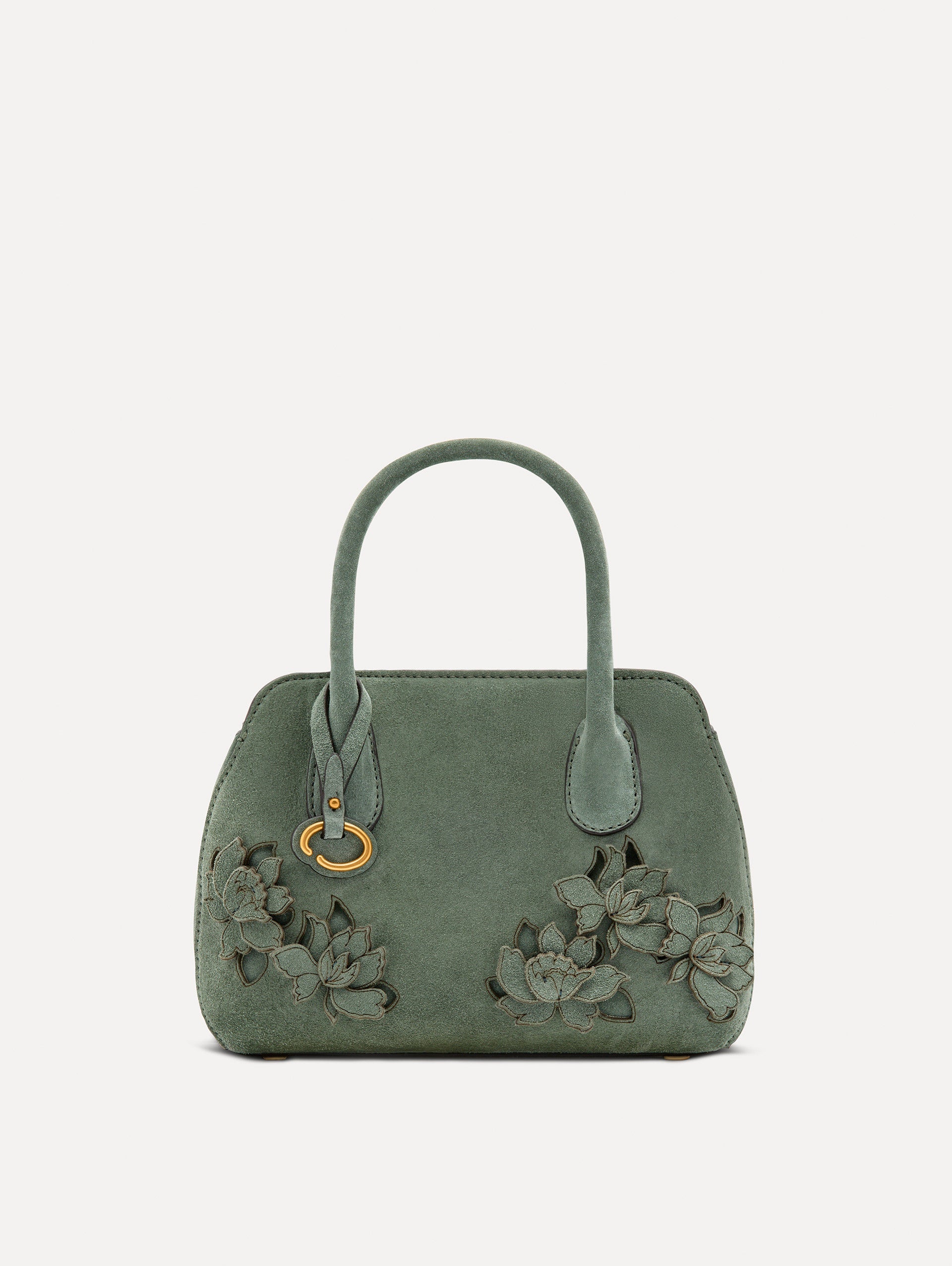 Front view of The Mini Ivy With Laser Cut Flowers in sage which has a compartment with top handles and various Oscar 'O' emblems on the hangtag and magnetic closure.