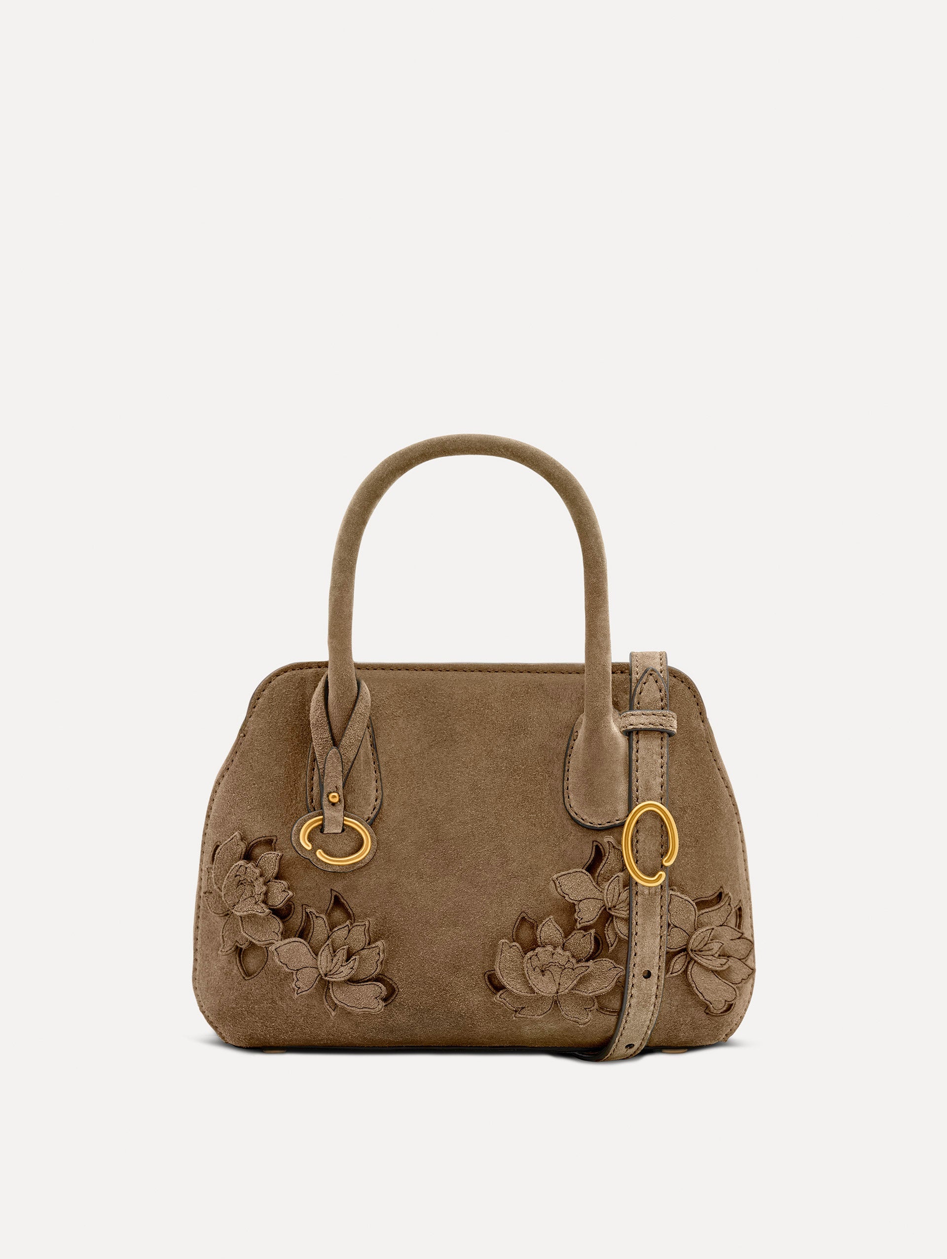 The Mini Ivy With Laser Cut Flowers in taupe has a compartment with top handles and a removeable shoulder strap with various Oscar 'O' emblems on the hangtag and magnetic closure.