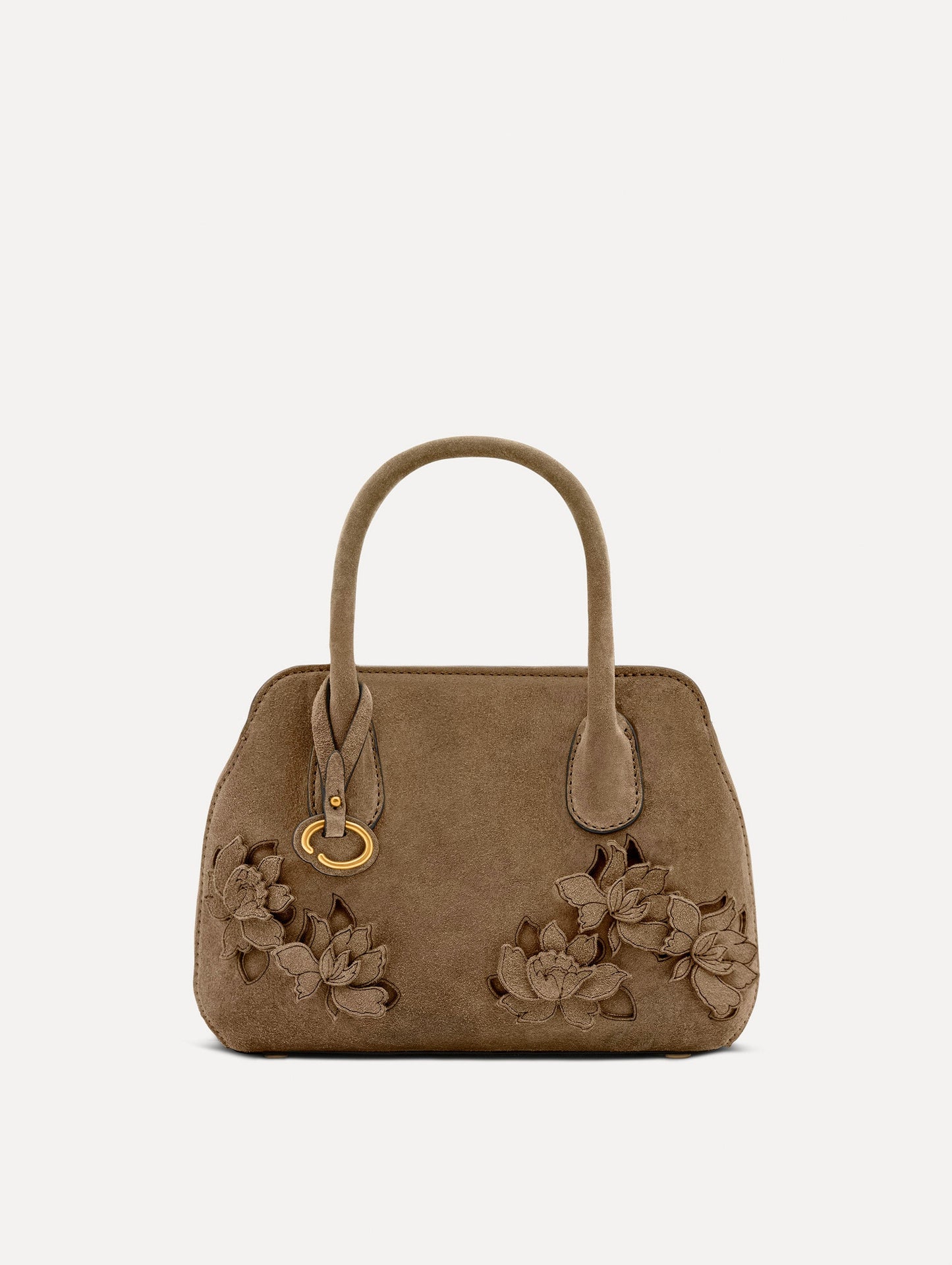Front view of The Mini Ivy With Laser Cut Flowers in taupe which has a compartment with top handles and various Oscar 'O' emblems on the hangtag and magnetic closure.
