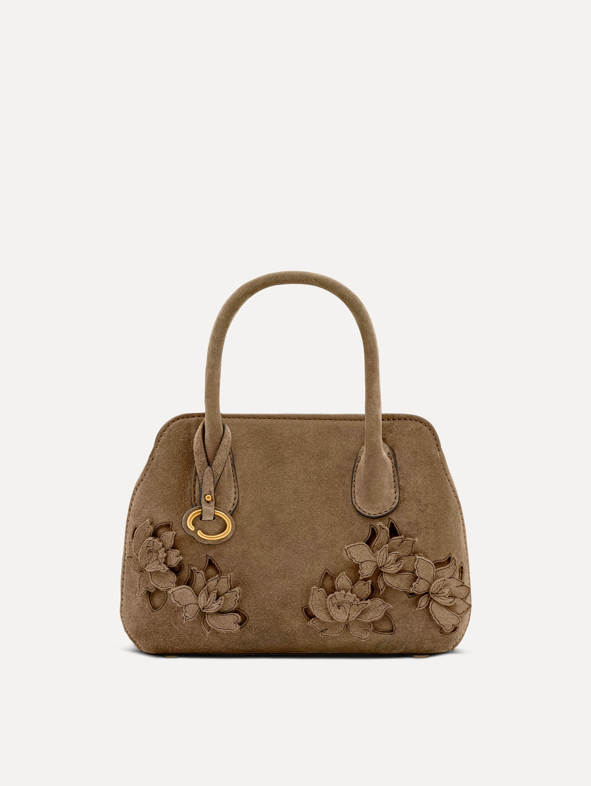 Front view of The Mini Ivy With Laser Cut Flowers in taupe which has a compartment with top handles and various Oscar 'O' emblems on the hangtag and magnetic closure.