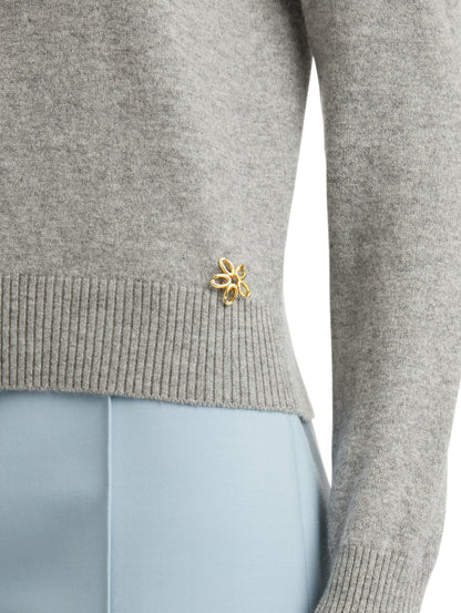 Zoomed in image of gold 'O' Flower emblem made of the interlocking Oscar 'O'.