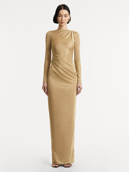 Full body front view image of model wearing a gold metallic jersey gown with a high neckline and long sleeves with draping at the shoulder and waist.
