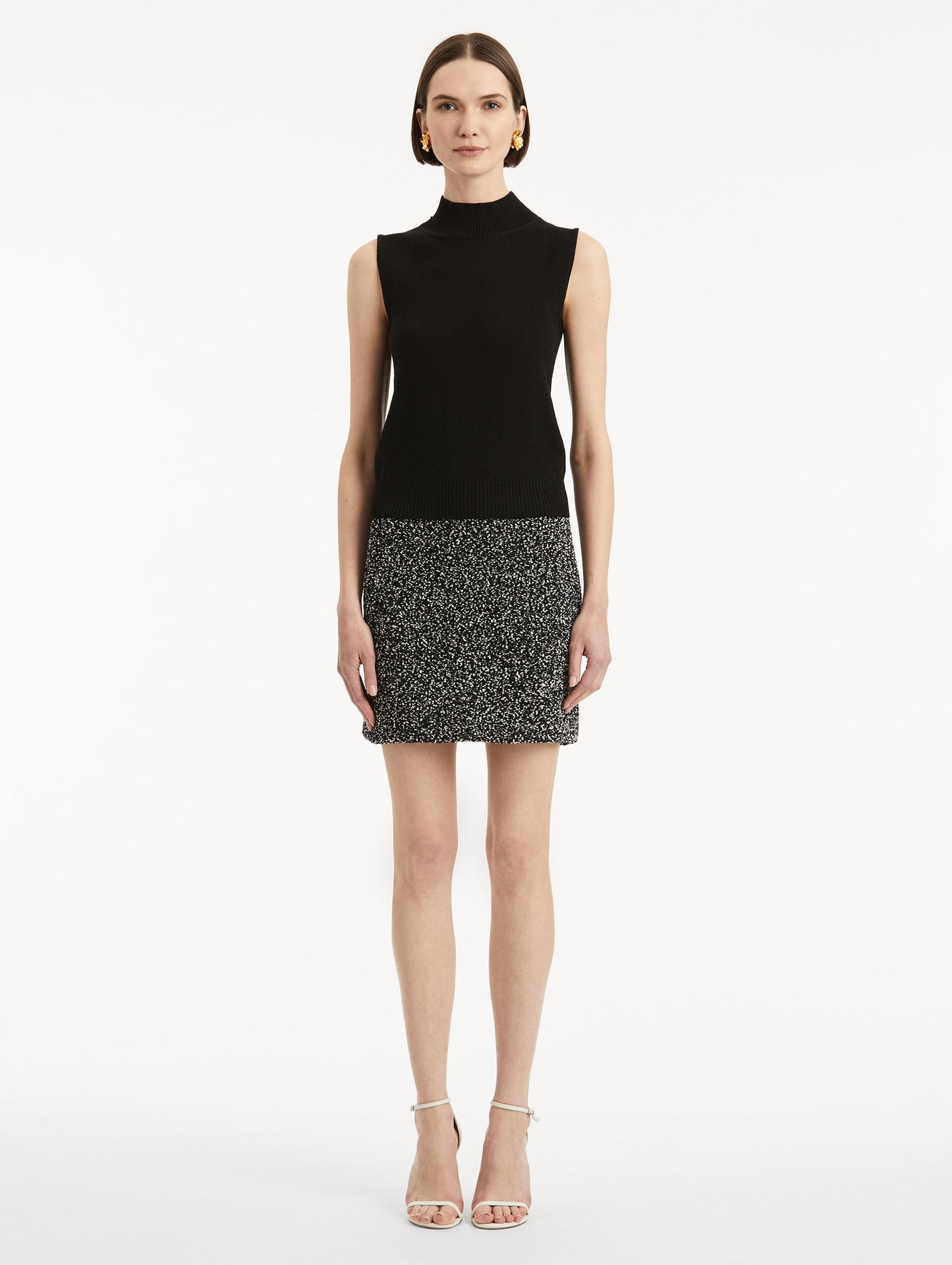 Full body front view of model earing black pullover with mock neckline and ribbed trim.