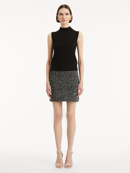 Full body front view of model earing black pullover with mock neckline and ribbed trim.