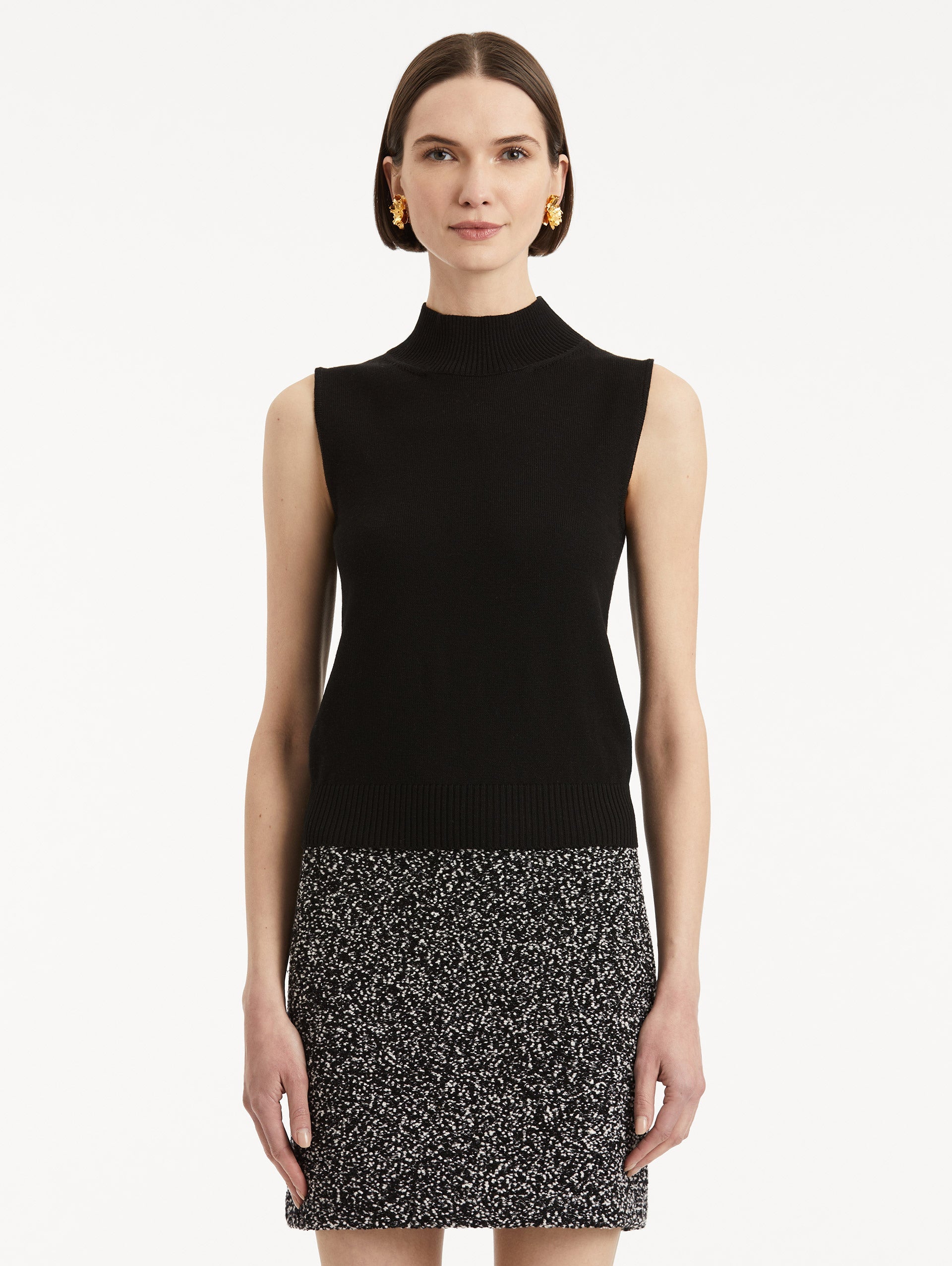Front view of model wearing black pullover with mock neckline and ribbed trim.