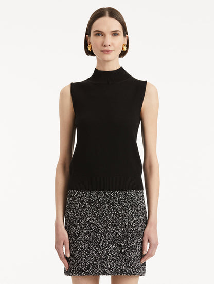 Front view of model wearing black pullover with mock neckline and ribbed trim.