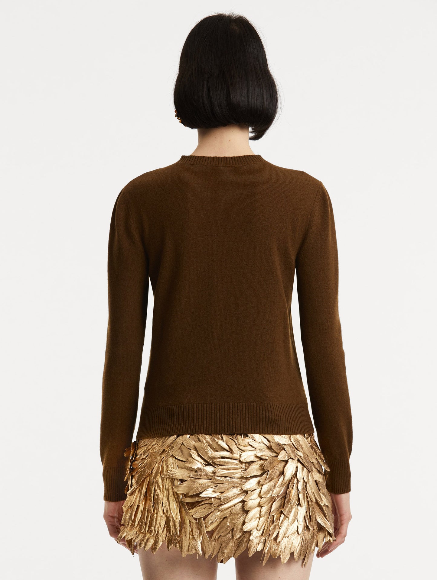 Back view of model wearing brown pullover with long sleeves and a crew neckline.