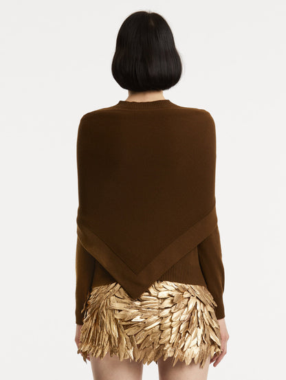 Back view of model wearing brown pullover with long sleeves and a crew neckline. Features matching shawl draped over shoulders.