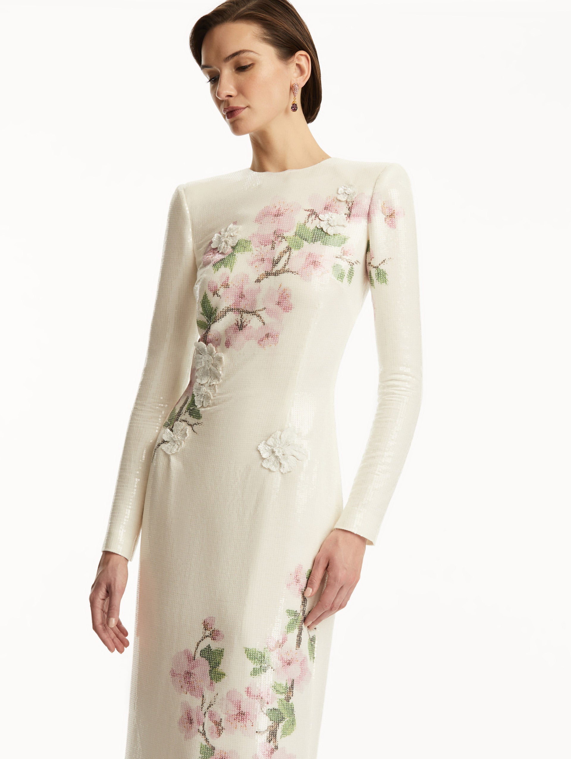 Model wearing white long sleeve sequin gown with pink cherry blossoms. Zoom View