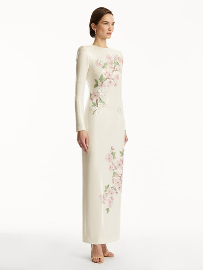 Model wearing white long sleeve sequin gown with pink cherry blossoms. Side View