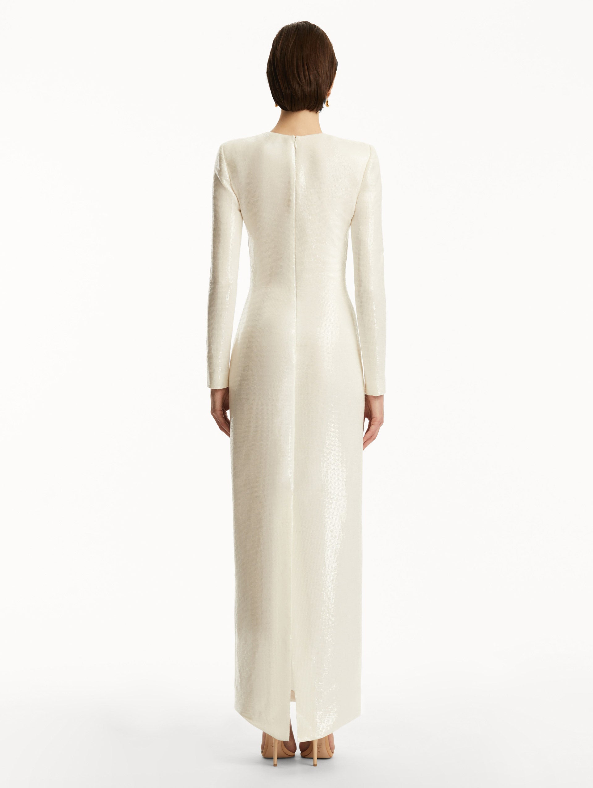 Model wearing white long sleeve sequin gown with pink cherry blossoms. Back View
