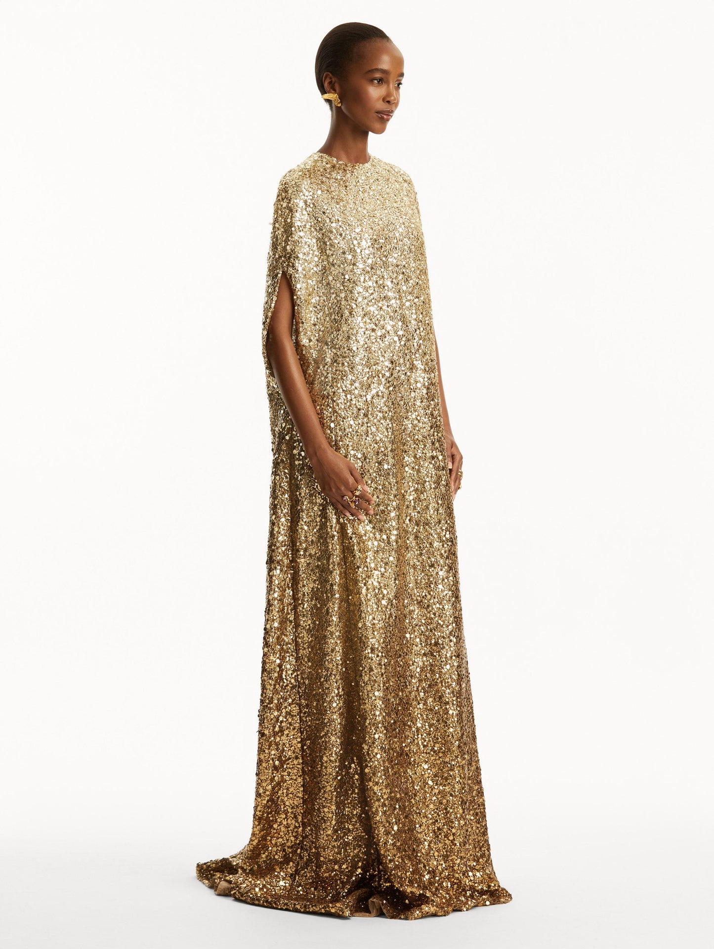 Model wearing ombre gold sequin embroidered caftan. Side view