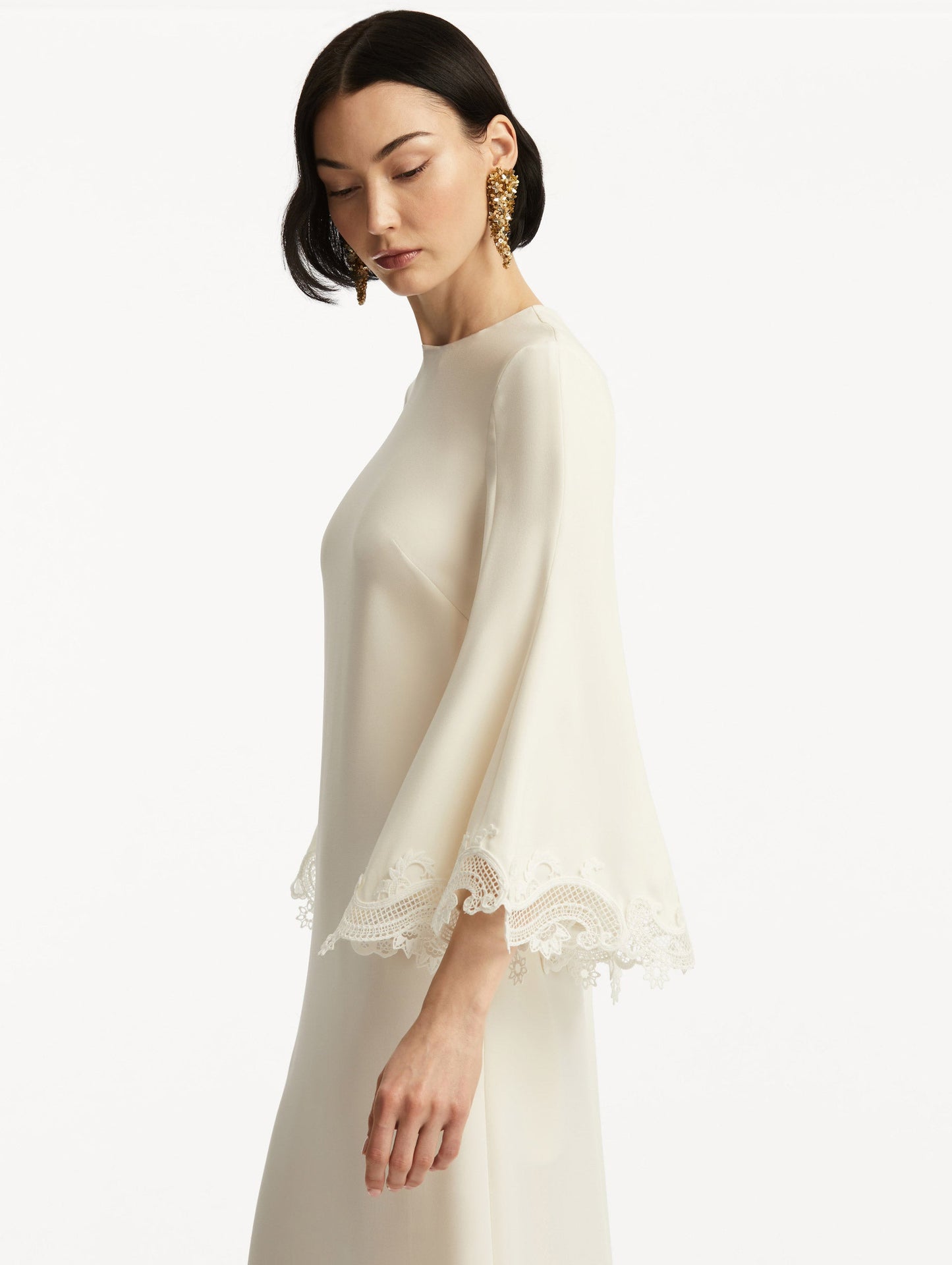 Model wearing white long sleeve caftan with lace detail on the cuff of the bell sleeves. Zoom view.