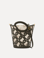The Oscar chain link bucket tote in olive green with a large o forming the top handle and detachable shoulder strap, paired with an ombre floral dress. Front View.