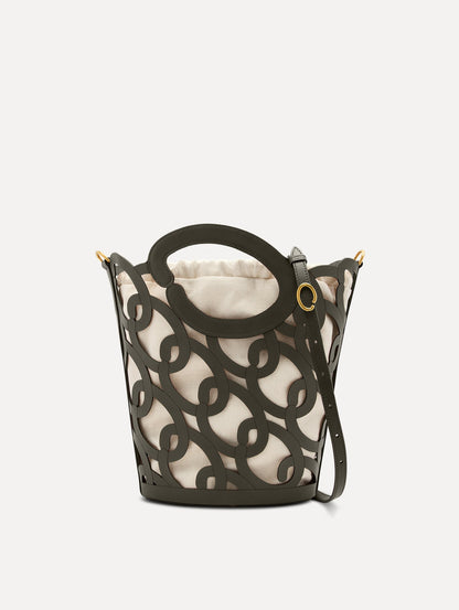 The Oscar chain link bucket tote in olive green with a large o forming the top handle and detachable shoulder strap, paired with an ombre floral dress. Front View.