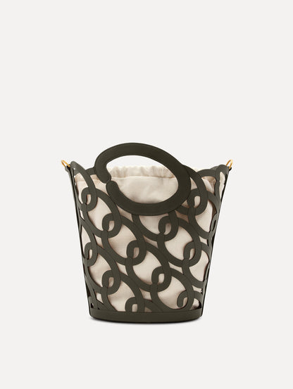 The Oscar chain link bucket tote in olive green with a large o forming the top handle and detachable shoulder strap, paired with an ombre floral dress. Front View.