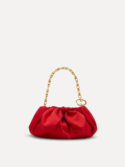 Small satin clutch in taupe with a bow detail on the top, and detachable gold chain shoulder strap. Front View.