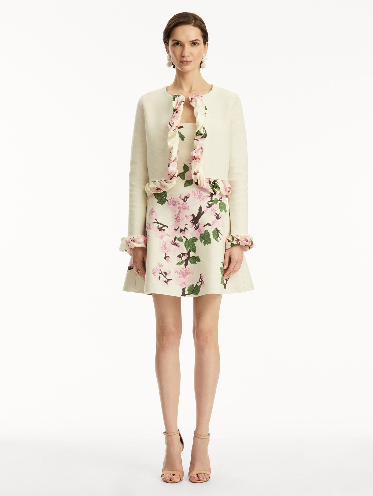 White cardigan with pink bubble twist trim printed with cherry blossoms, paired with cherry blossom tweed dress. Front view