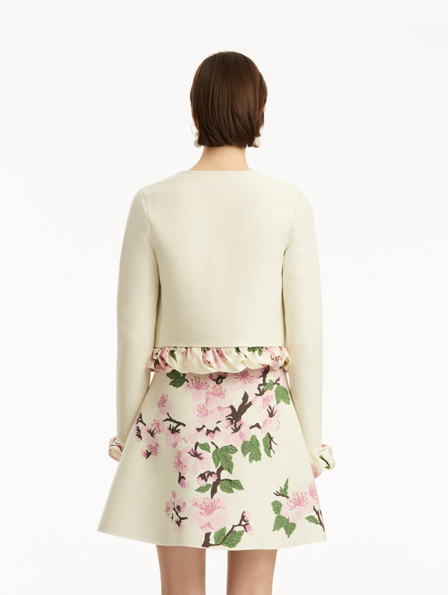 White cardigan with pink bubble twist trim printed with cherry blossoms, paired with cherry blossom tweed dress. Back view