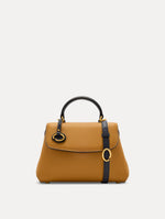 The Mini Poppy Handbag in Honey with Black Top Handle. Adorned with Oscar de la Renta's signature O at the ornamental bag tag. Front View