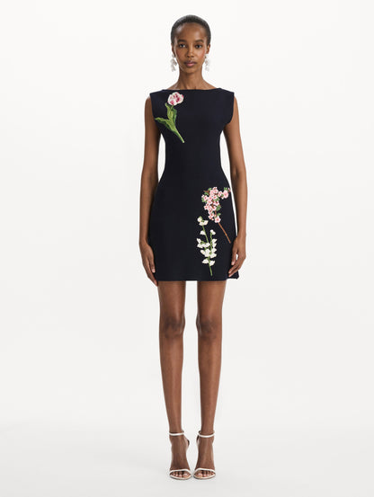 The model is wearing the mixed botanical embroidered dress with an A-line silhouette in a navy wool blend. Front view.