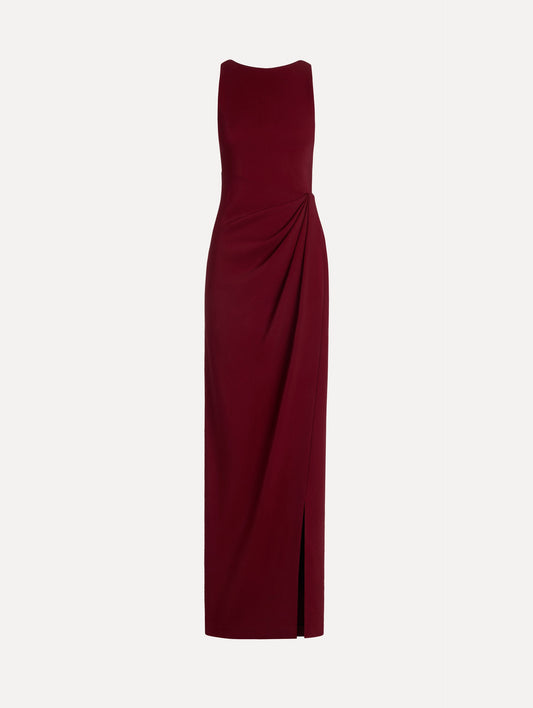 The model is wearing the drape-detailed cady gown with a sleeveless silhouette in the color claret.