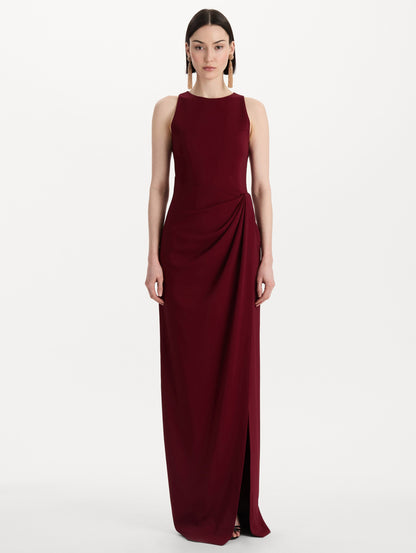 The model is wearing the drape-detailed cady gown with a sleeveless silhouette in the color claret. Front view.
