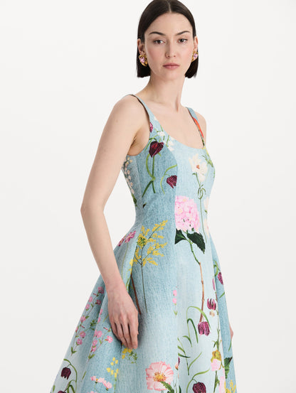 The model is wearing the mixed botanical faille gown with a sleeveless scoop neckline and a bold floral print in blue multi. Zoom view.