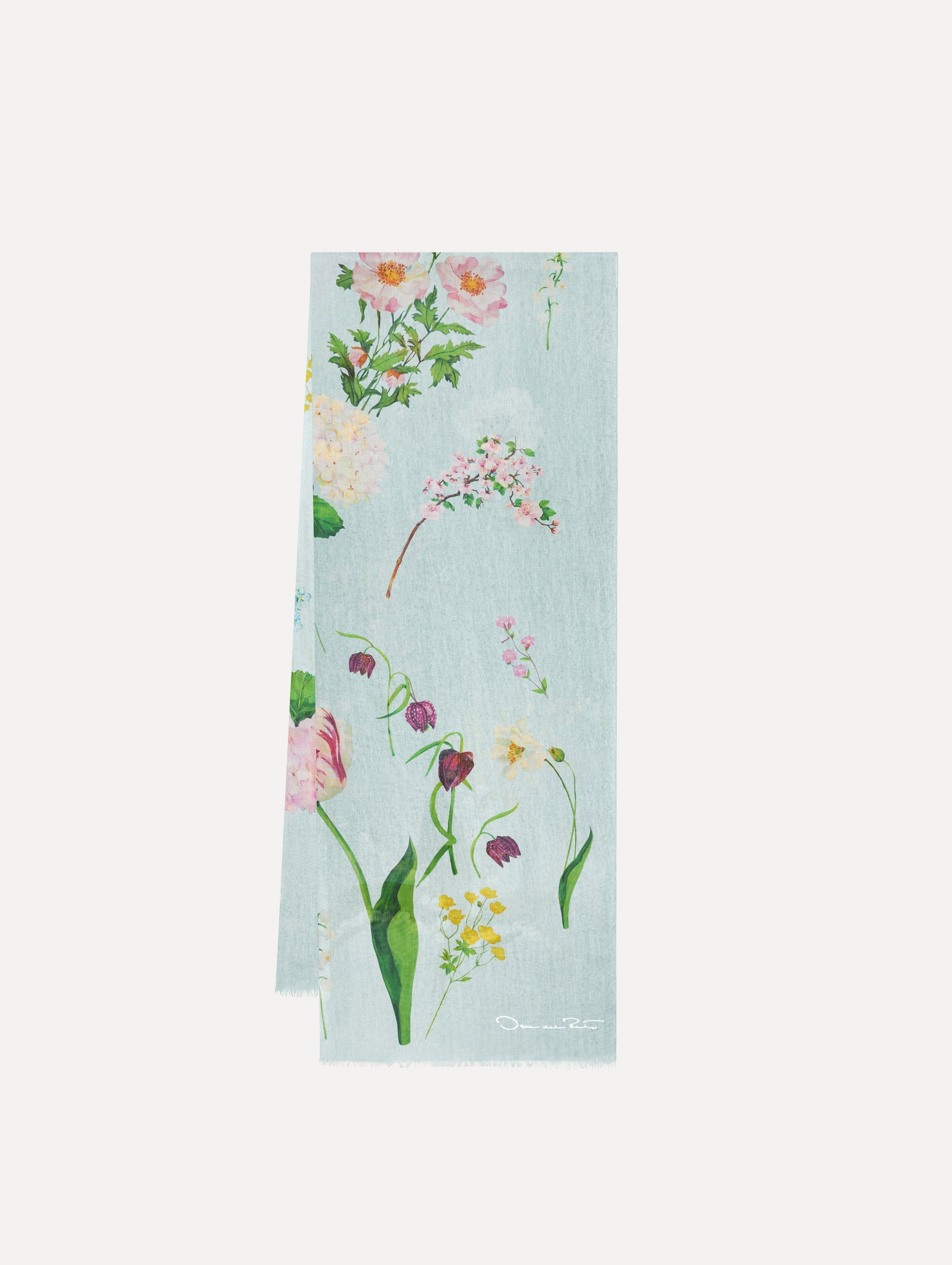 The model is wearing the mixed botanical scarf with an all-over floral print in the color light blue multi.