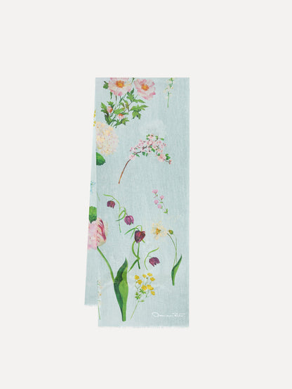 The model is wearing the mixed botanical scarf with an all-over floral print in the color light blue multi.