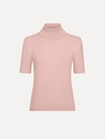 The model is wearing the turtleneck wool short-sleeve pullover with a fold-over neckline in the color blush.