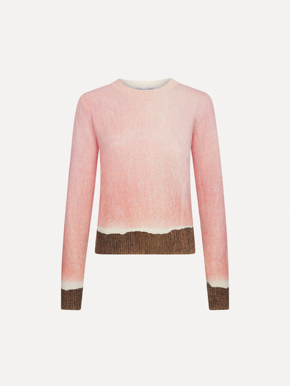 The model is wearing the ombré crewneck pullover with a painterly print in a pink and brown palette.