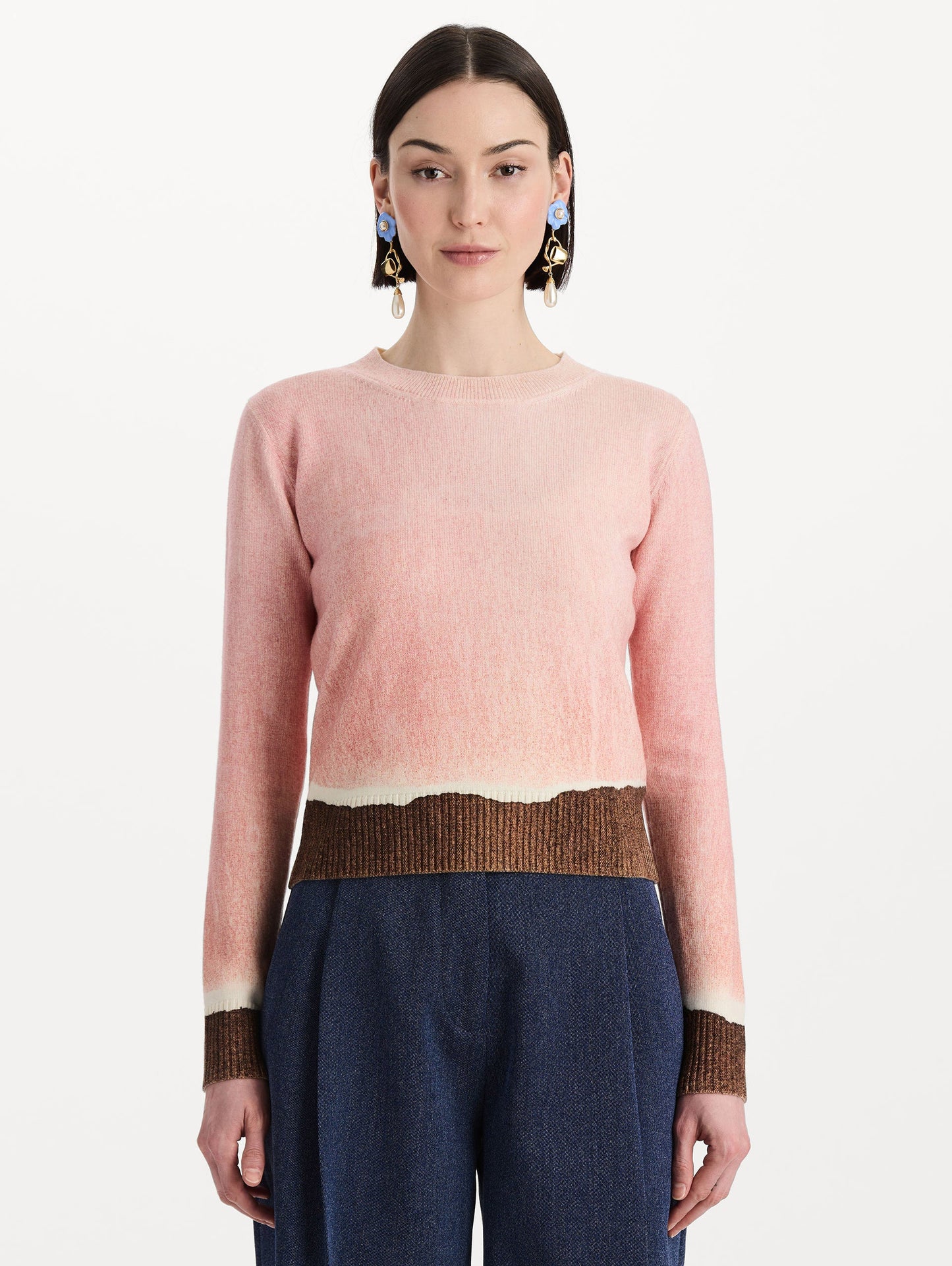 The model is wearing the ombré crewneck pullover with a painterly print in a pink and brown palette. Front view.