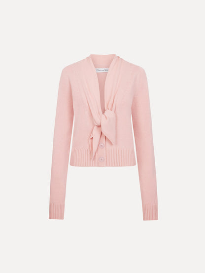 The model is wearing the tie-neck cardigan in blush wool with a tie V-neck detail.