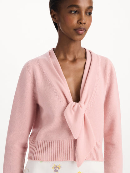 The model is wearing the tie-neck cardigan in blush wool with a tie V-neck detail. Zoom view.