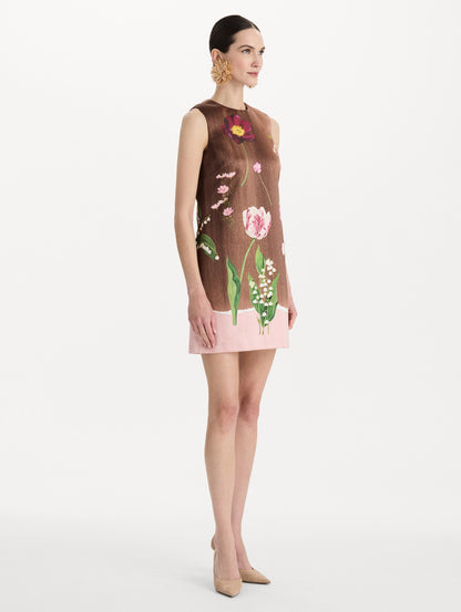 The model is wearing the mixed botanical shift dress with a border print and a sleeveless silhouette. Side view.