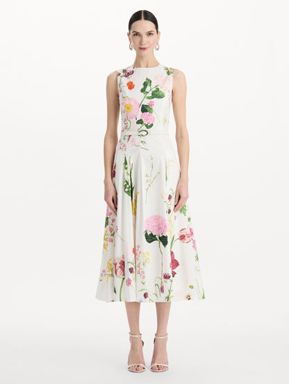 The model is wearing the mixed botanical cotton poplin sleeveless dress with an all-over floral print in white multi. Front view.